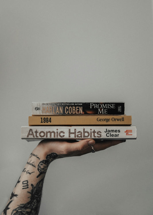 a person holding a stack of books in their hand