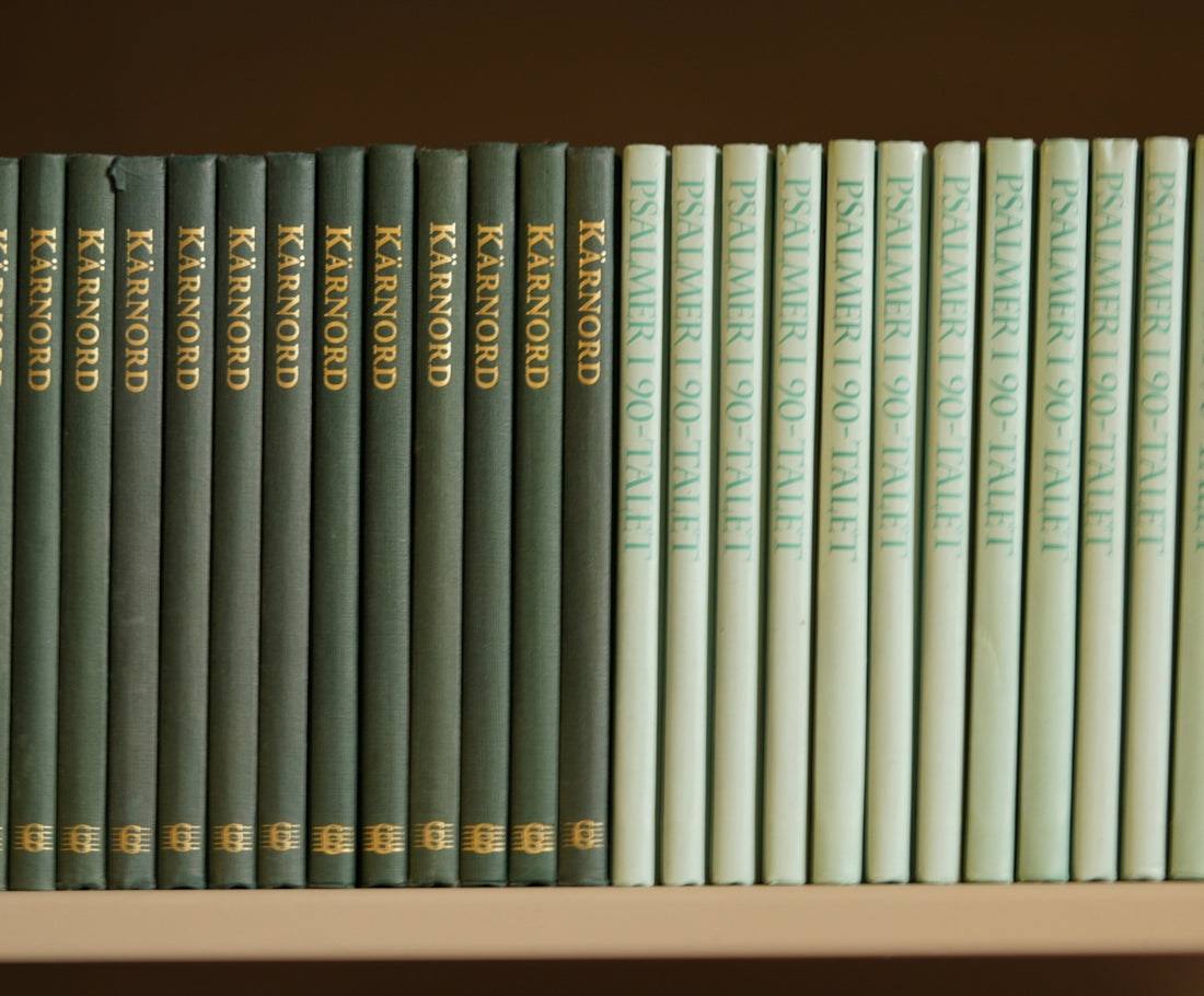 a row of books sitting on top of a white shelf