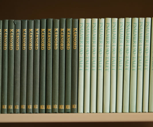 a row of books sitting on top of a white shelf