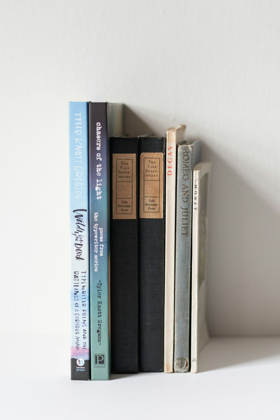 A white shelf with a couple of books on top of it