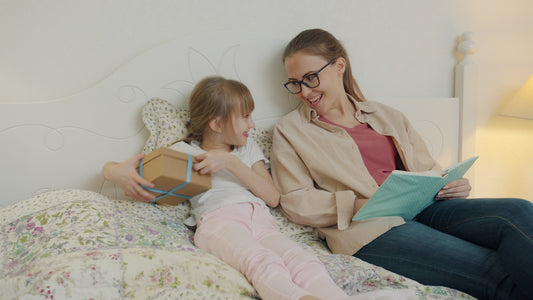 Daughter gives mother a gift while reading